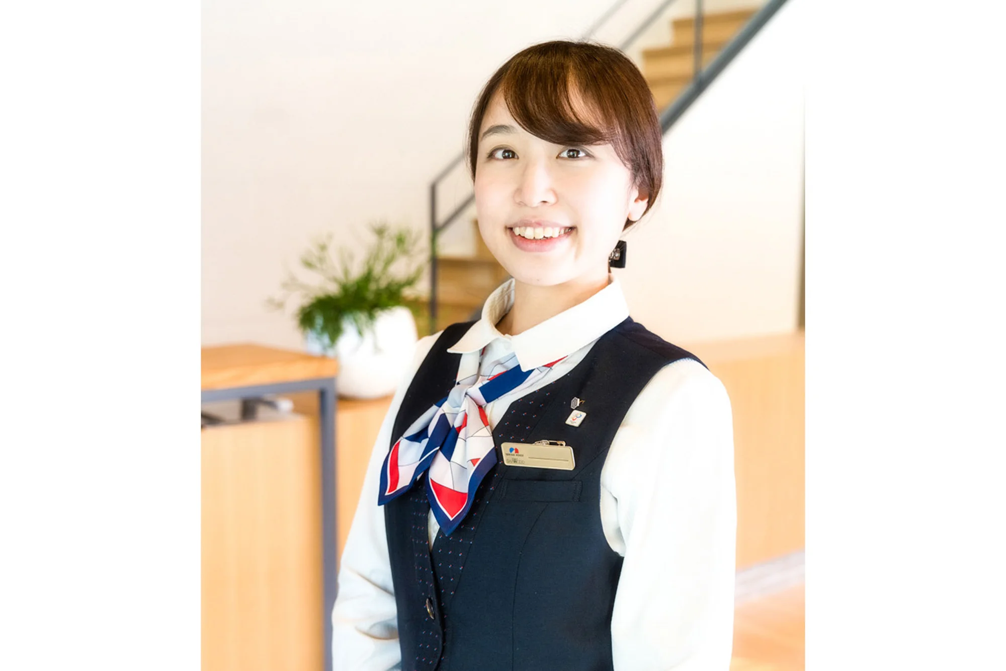 受付で笑顔を見せるスタッフのポートレート